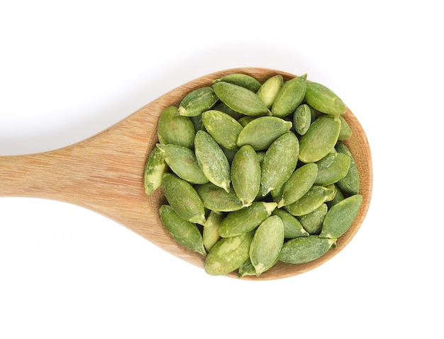 Pumpkin seeds in the spoon on white background