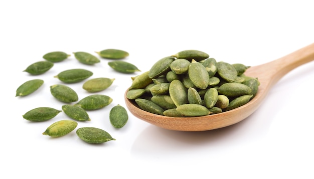 Pumpkin seeds in the spoon on white isolated