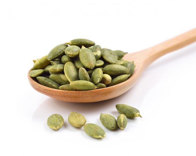 Pumpkin seeds in the spoon on white space