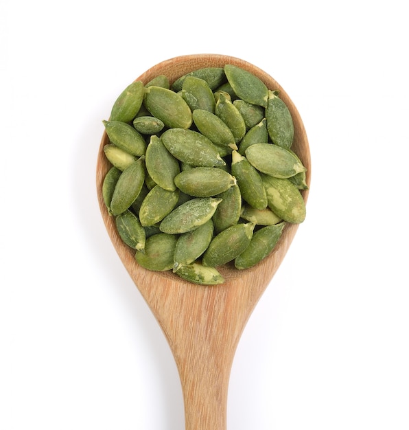 Pumpkin seeds in the spoon on white space