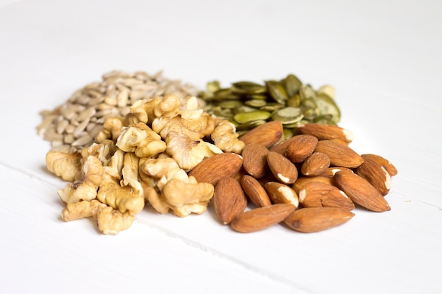 Pumpkin seeds, sunflower seeds, almonds, walnuts on wooden 