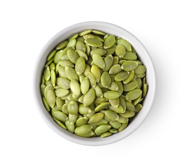 Pumpkin seeds in white bowl isolated