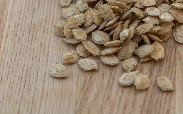 Pumpkin seeds on wooden background copy space