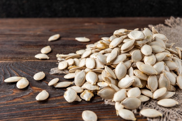 Pumpkin seeds on wooden table.