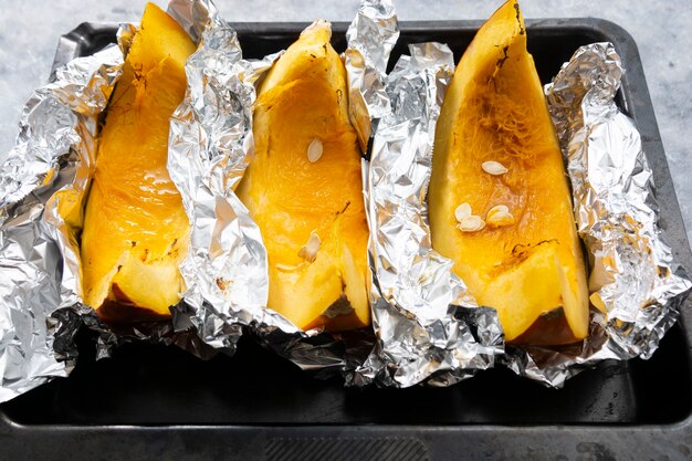 Photo pumpkin slices in baking tray