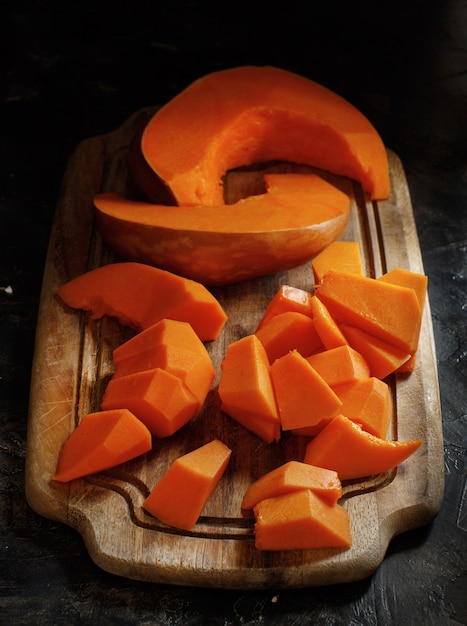 Pumpkin slices on a white wooden background close up