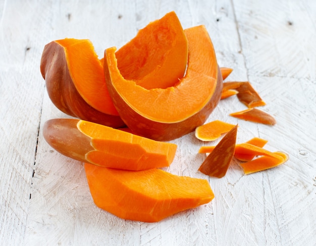 Pumpkin slices on a white wooden table close up