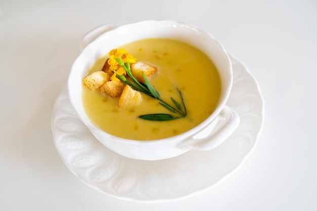 Foto zuppa di zucca bella decorata da pane e fiori di verdure