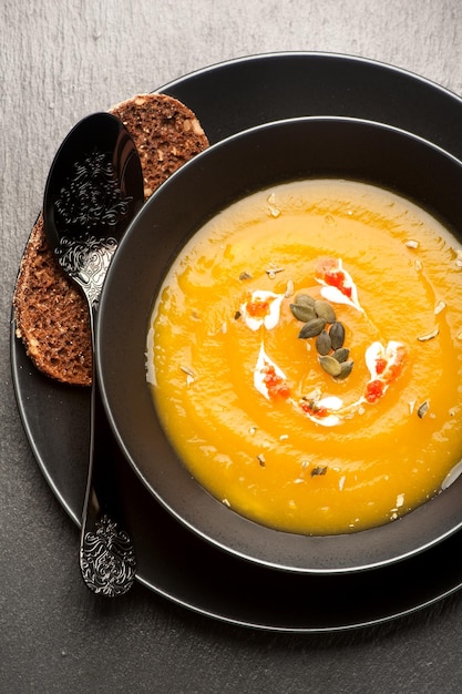 Pumpkin soup on a black background vertical