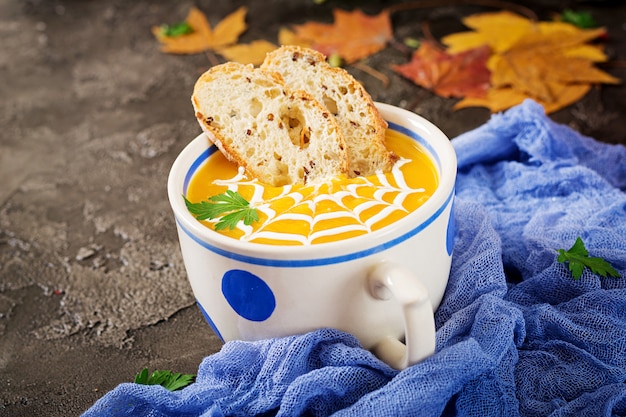 Pumpkin soup in a bowl served with parsley and pumpkin seeds. Vegan soup. 