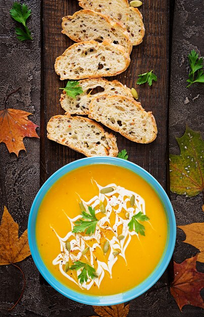 Zuppa di zucca in una ciotola servita con prezzemolo e semi di zucca.