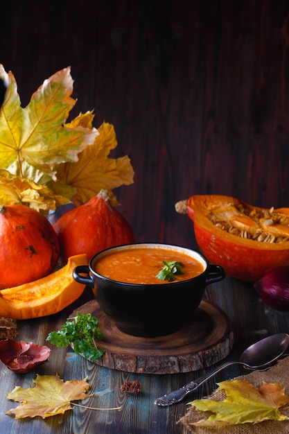 Pumpkin soup puree with greens in a plate  table. 