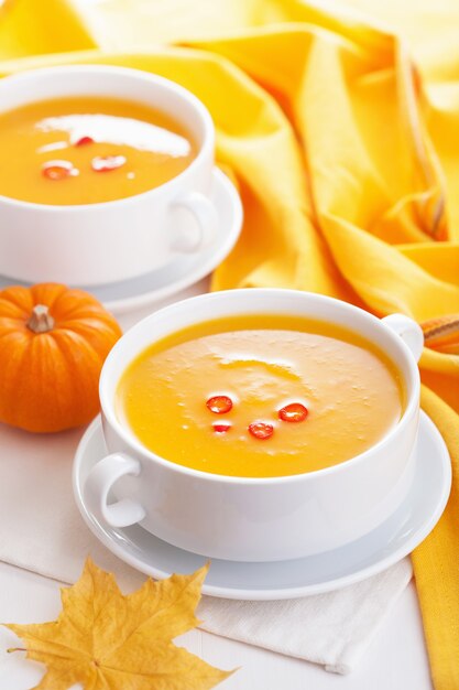 Pumpkin soup in white bowl