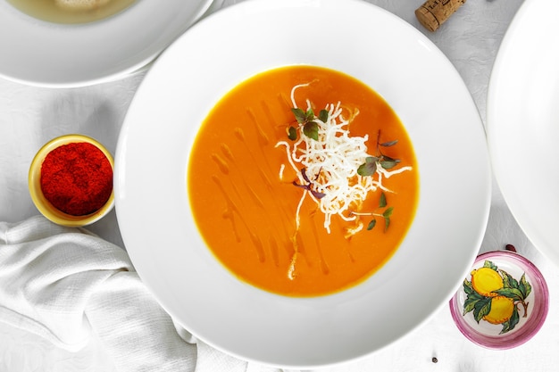 Pumpkin soup on white table top view