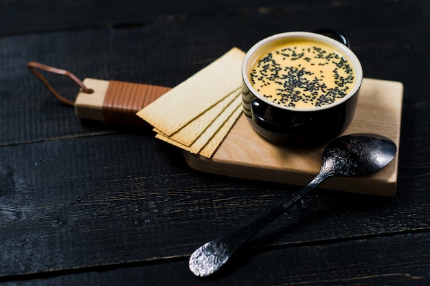 Pumpkin soup with black sesame and crackers.