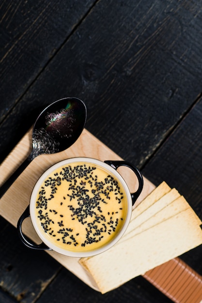 Pumpkin soup with black sesame and crackers.