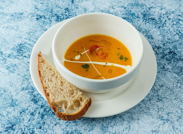 pumpkin soup with bread served in bowl isolated on background top view of italian food