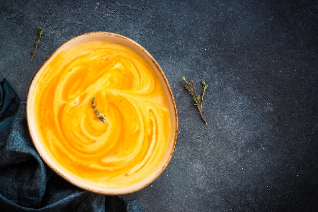 Pumpkin soup with cream at black stone table Healthy eating Top view with copy space