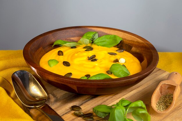 Pumpkin soup with cream on the dark wooden background Top view Copy space