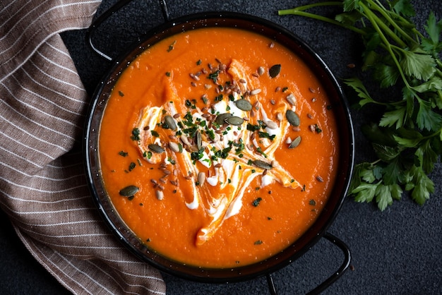 Pumpkin soup with cream and parsley in bowl