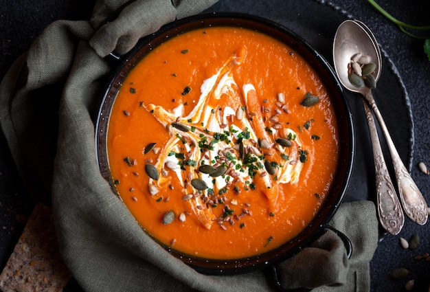 Pumpkin soup with cream and parsley in bowl