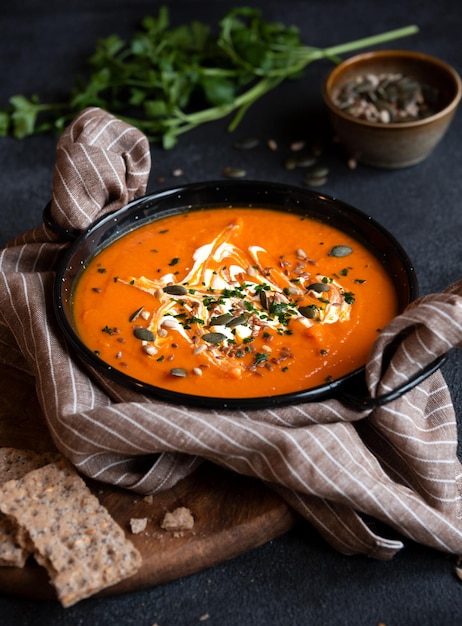 Pumpkin soup with cream and parsley in bowl