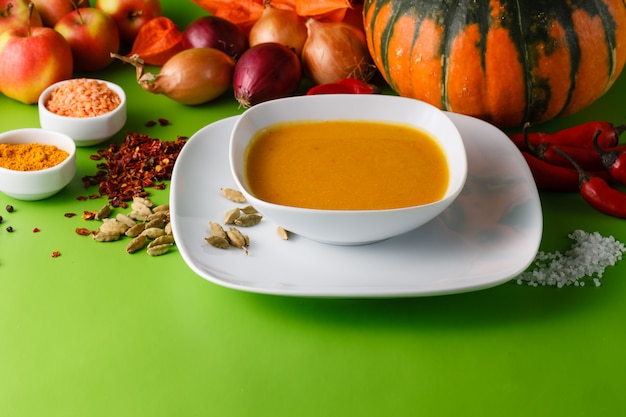 Pumpkin soup with onion and pepper on green shadowless backgroud