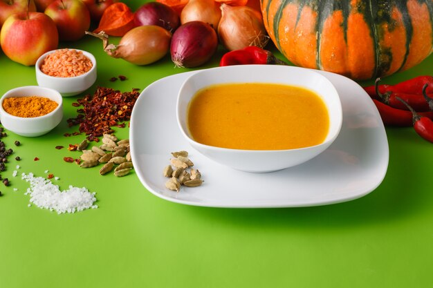 Pumpkin soup with onion and pepper on green shadowless backgroud