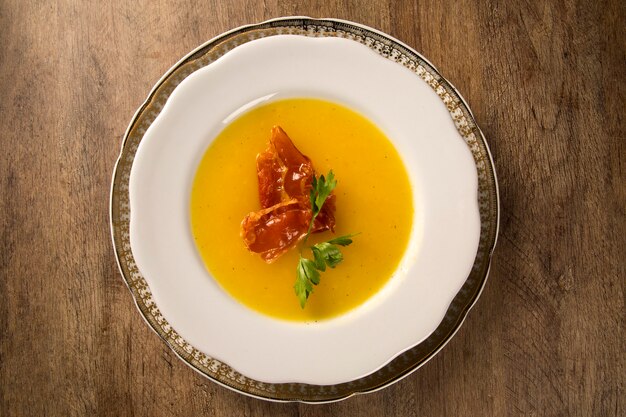 Pumpkin Soup with prosciutto on table