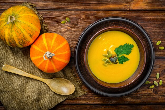 Pumpkin soup on wooden background