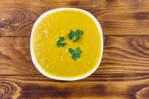 Pumpkin soup on a wooden table Top view