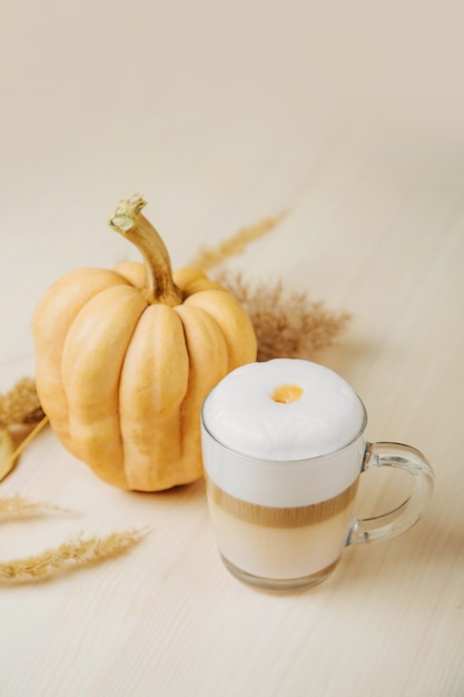 Pumpkin Spice Latte. Cup of Latte with Pumpkin and Fall Decor. Traditional Autumn Coffee Drink.