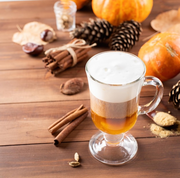 Pumpkin spice latte in a glass mug with cinnamon and ginger