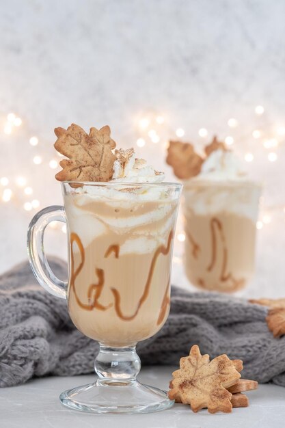 Pumpkin spice latte in een glazen mok met karamel en kaneel met herfstdecoratie