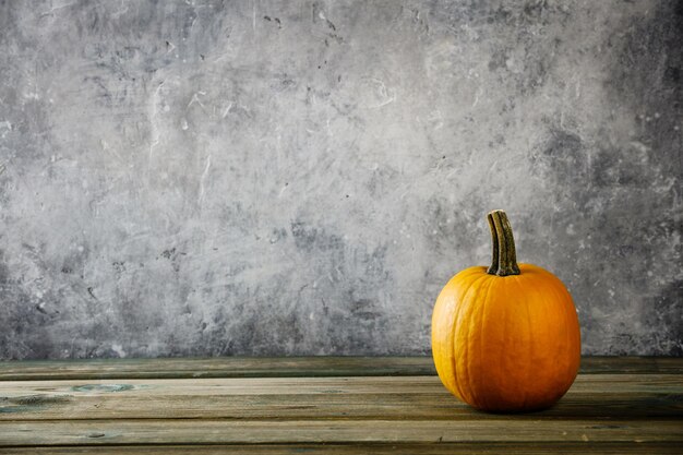 Photo pumpkin on table against wall during autumn