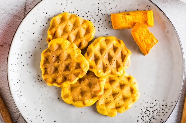 Pumpkin waffles on a plate on the table Homemade baking Top view Closeup