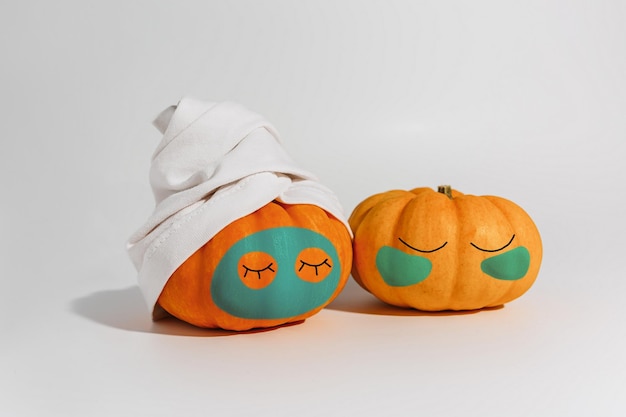 Pumpkin with facial mask and towel isolated on white background Space for text mockup spa and Halloween concept