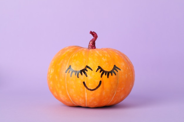 Photo pumpkin with smile on violet, space for text