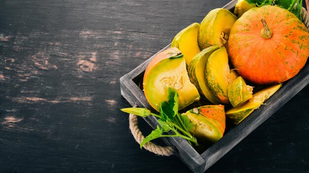 Pumpkin in a wooden box Pumpkin Sliced On a wooden table Free space for text Top view