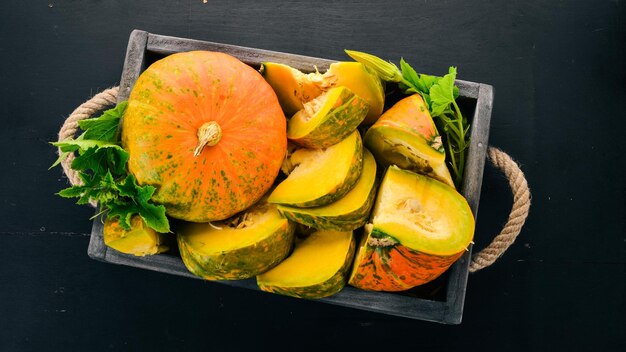 Zucca in una scatola di legno zucca affettata su un tavolo di legno spazio libero per il testo vista dall'alto