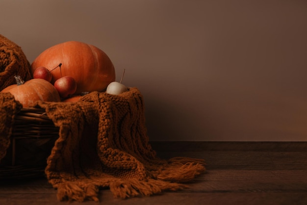 pumpkins, apples, candles, leaves on a wooden background on sunset, place for your text