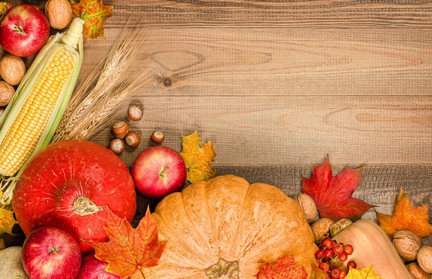 Pumpkins apples corn nuts berries and leaves on a wooden table\
thanksgiving day