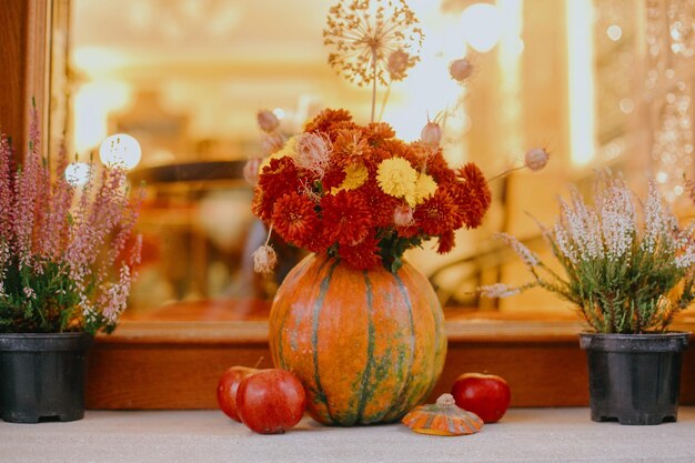 Pumpkins and autumn flowers stylish festive decor of city street Happy Thanksgiving Halloween street decor