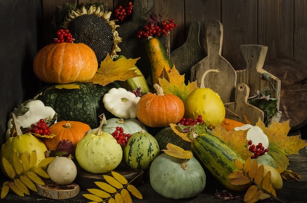 Pumpkins, berries and autumn leaves on an old wooden table