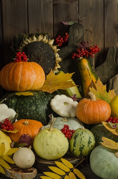 Pumpkins, berries and autumn leaves on an old wooden table