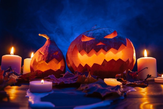 Тыквы на синем фоне с дымом при свечах стоят на деревянном столе на хэллоуин