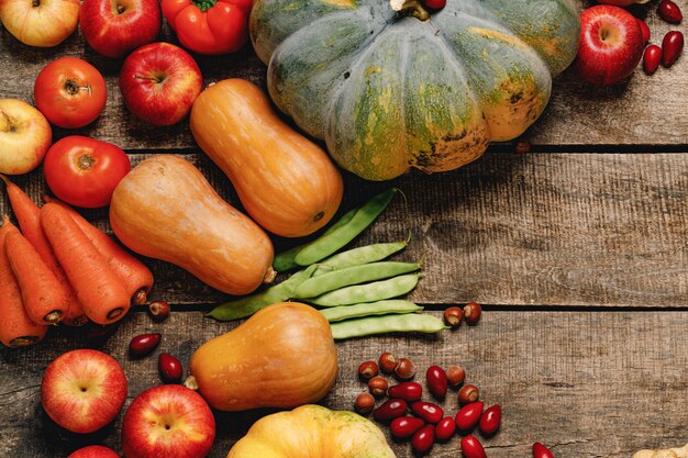 Pumpkins, green beans and dogwood on wooden surface