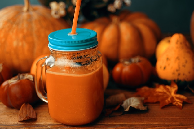 Pumpkins juice in bottles with pumpkins.