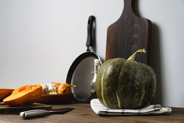 Zucche sul tavolo della cucina contro il muro grigio