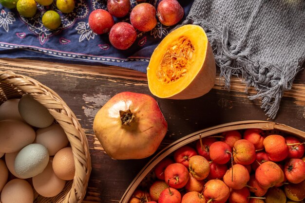 Photo pumpkins and many other colors and varieties of fruits and vegetables are on the wood grain table